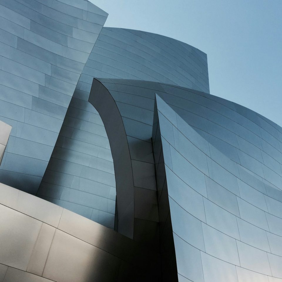 Abstract architectural details of a modern metallic building against a clear sky.